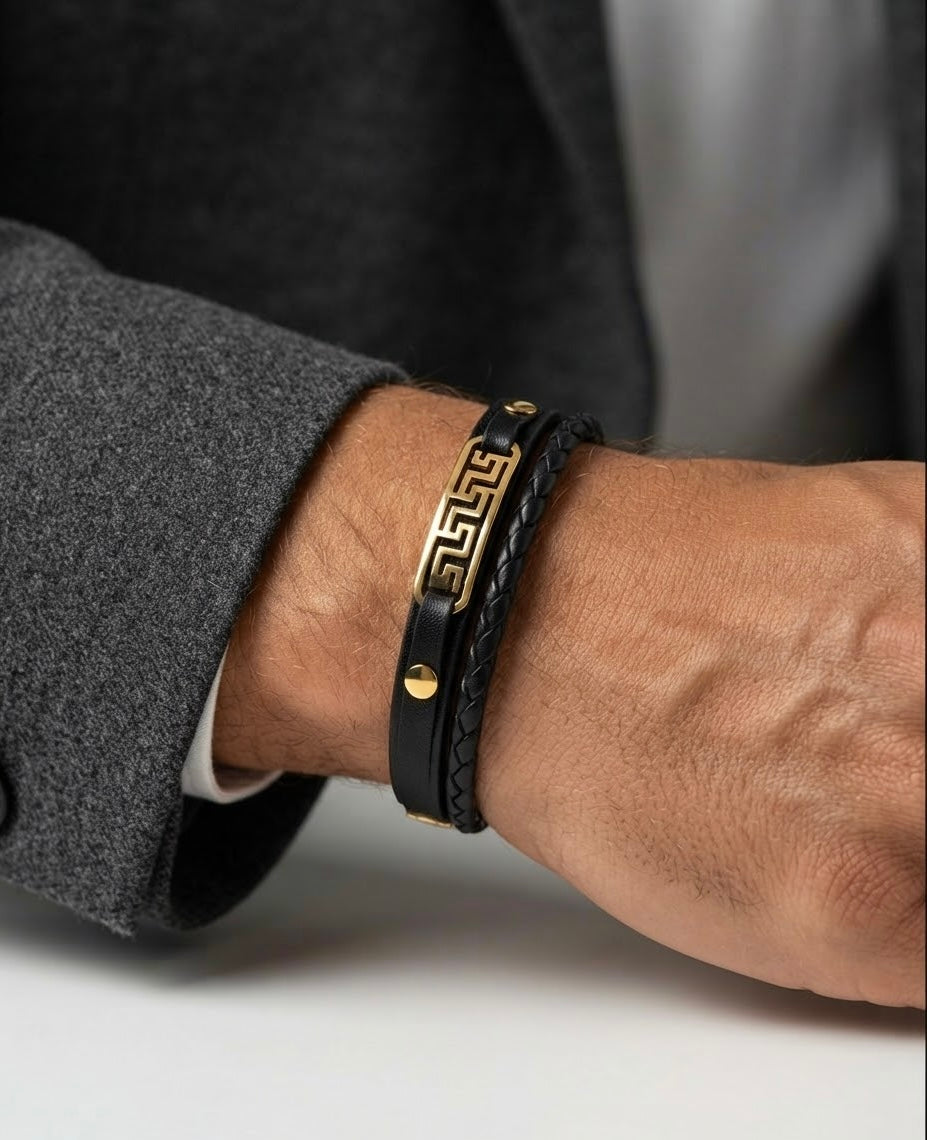 Schwarzes Lederarmband für Herren mit Mäander-Element aus 18 Karat Gold, elegant am Handgelenk getragen.