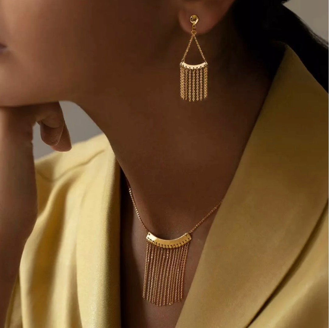 Nahaufnahme eines Ensembles aus 18k Gold mit Kette und Ohrringen im Wasserfall-Stil – Design Barân-e Zarrin, getragen am Ohr und Hals