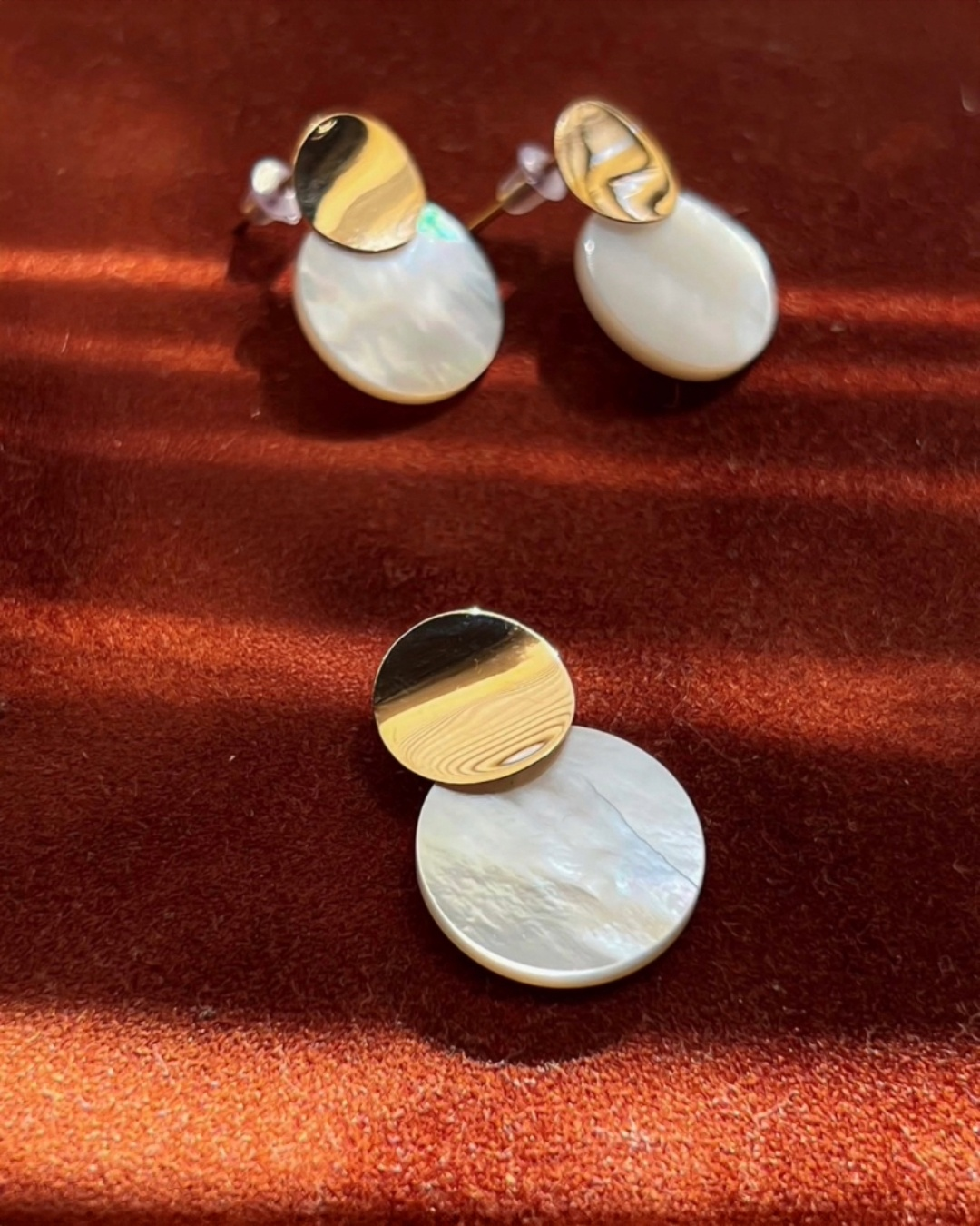 Perlmutt-Ohrringe aus 18k Gelbgold auf Samtuntergrund, runde Scheibenform mit matter Goldoberfläche, hochwertiger eleganter Damenschmuck