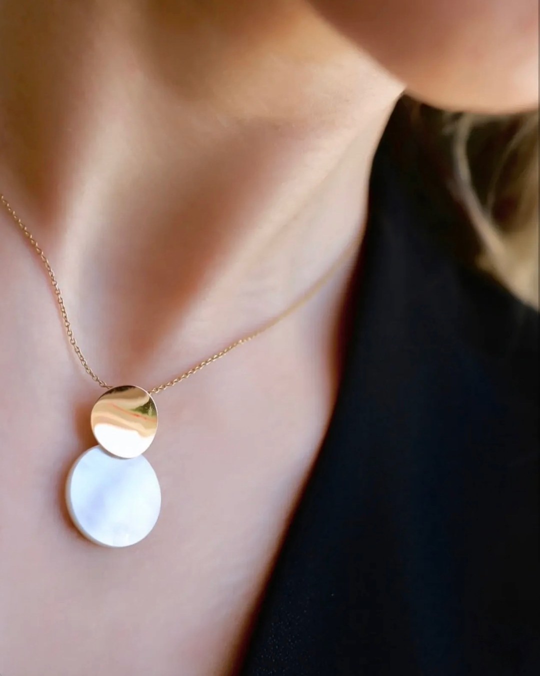 Model trägt 18k Gelbgold Halskette mit rundem Anhänger aus Gold und Perlmutt, eleganter minimalistischer Damenschmuck