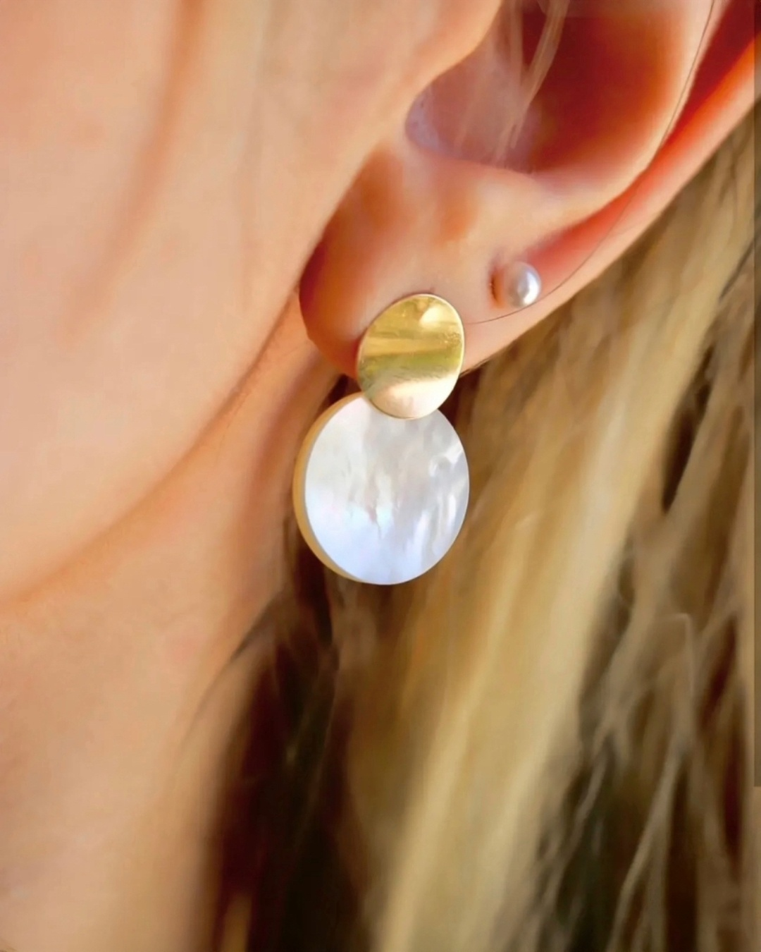 Nahaufnahme eines 18k Gelbgold Perlmutt-Ohrrings am Ohr getragen, zeitlos eleganter Ohrschmuck