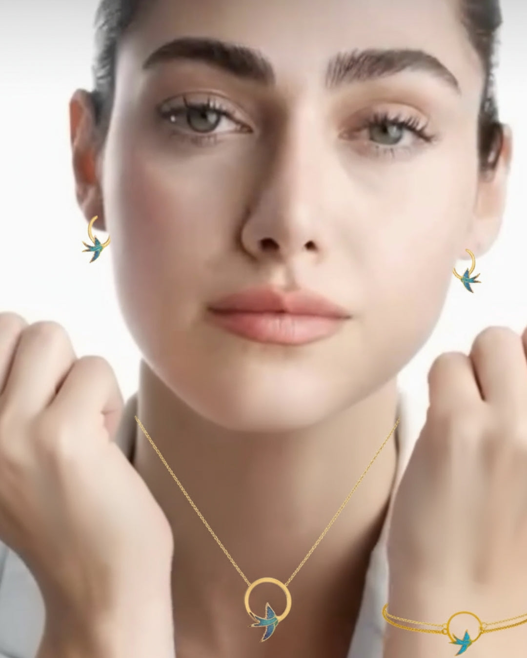 Model trägt das 18k Gold Schmuckset Parastoo mit Schwalbenmotiv – Halskette, Armband & Ohrstecker, eleganter Look mit weissem Blazer.