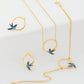 18k Gold Schmuckset mit Schwalbendesign – Halskette, Armband & Ohrstecker aus Gelbgold mit blauer Emaille, freigestelltes Produktbild.