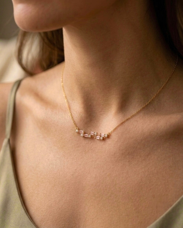 Edle 18 Karat Gelbgold-Halskette mit drei filigranen Elementen aus rosafarbenen Baguette-Steinen und weissen Zirkonia. Die zarte Goldkette schmiegt sich elegant an das Dekolleté und unterstreicht einen zeitlosen, femininen Look.