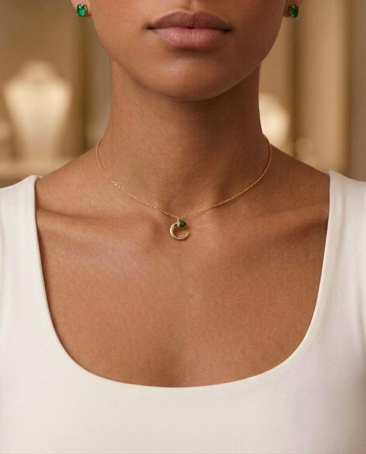 18 Karat Gelbgold Halskette mit modernem Kreis-Anhänger und grünem Edelstein, getragen von einem Model. Eleganter, minimalistischer Goldschmuck für Damen – handgefertigte Luxus-Halskette mit feiner Ankerkette, ideal als zeitloses Geschenk oder für den Alltag.