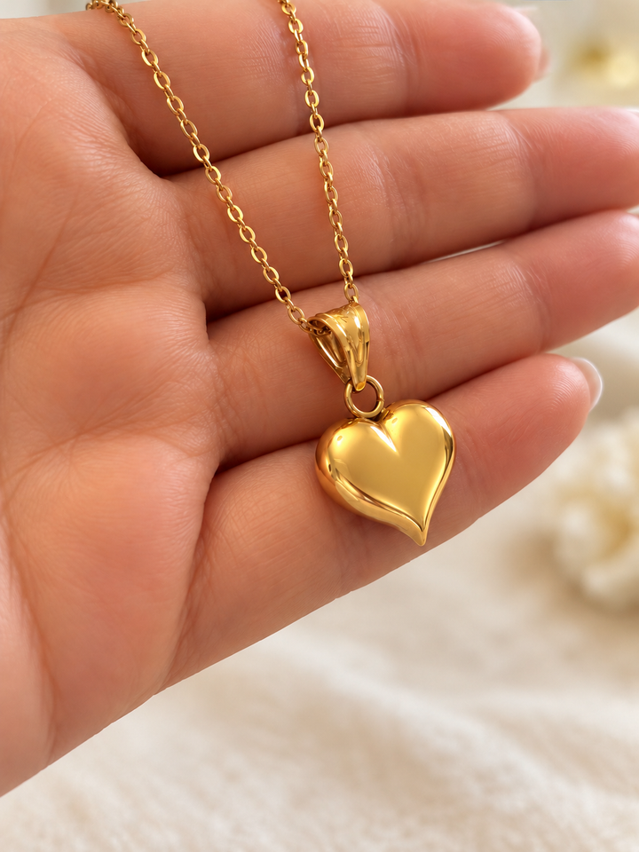 Seitliche Detailansicht des gewölbten Herzanhängers aus 18K Gelbgold mit polierter Oberfläche und dekorativer Anhängeröse.