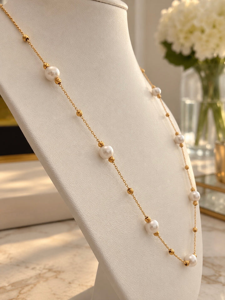 Elegante Gelbgold-Halskette Haft Morvarid mit weissen Perlen, präsentiert auf einer cremefarbenen Schmuckbüste.