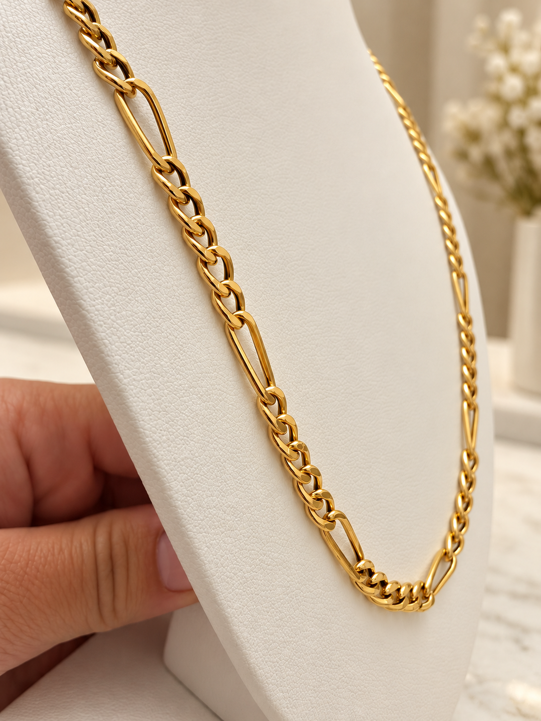 54,5 cm lange Figaro-Halskette aus 18K Gelbgold mit markanter Gliederstruktur auf einer cremefarbenen Schmuckbüste.