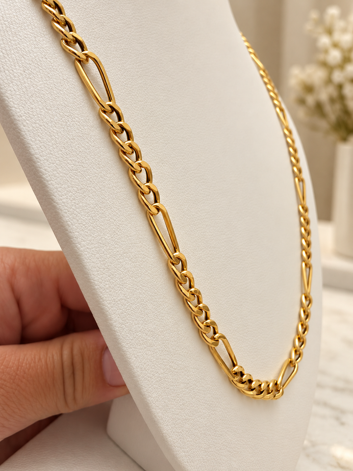 54,5 cm lange Figaro-Halskette aus 18K Gelbgold mit markanter Gliederstruktur auf einer cremefarbenen Schmuckbüste.