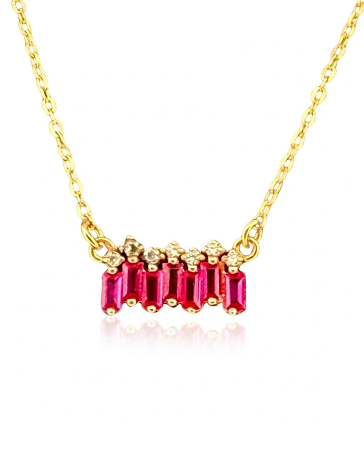 Detailaufnahme des Queranhängers – fünf rubinrote Baguette-Zirkonia, flankiert von kleinen hellen Steinen, gefasst in 18k Gelbgold.