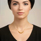 Porträt einer Frau mit eleganter Halskette aus 18k Gelbgold mit kleinen polierten Goldkugeln, minimalistischer luxuriöser Goldschmuck, feine handgefertigte Goldkette.