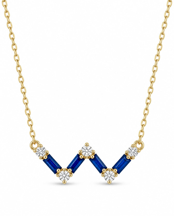 Detaillierter Cassiopeia-Anhänger mit dunkelblauen Elementen und goldenen Fassungen – auf zarter Kette aus 18k Gold