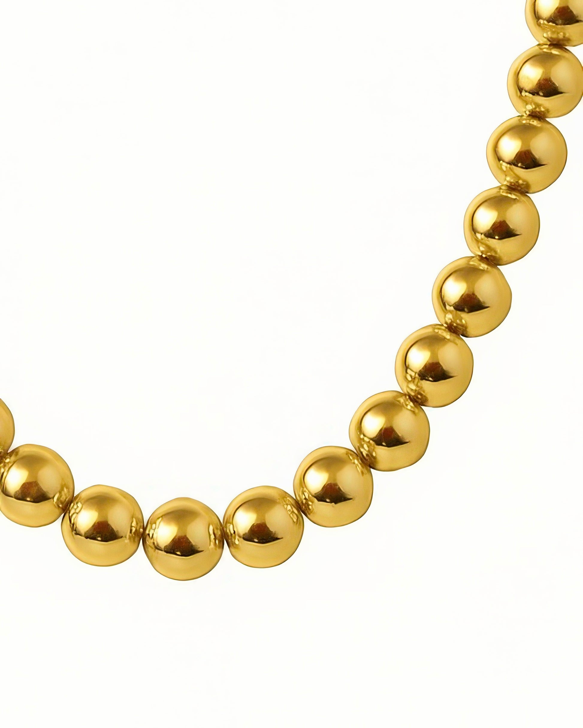 Nahaufnahme der 18k Goldkette mit glänzenden, perfekt polierten Goldkugeln, die sanft im Licht reflektieren