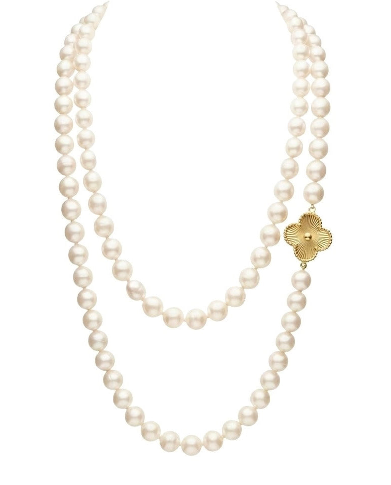 Detailaufnahme einer Halskette mit weissen Zuchtperlen und Kleeblatt aus 18k Gelbgold