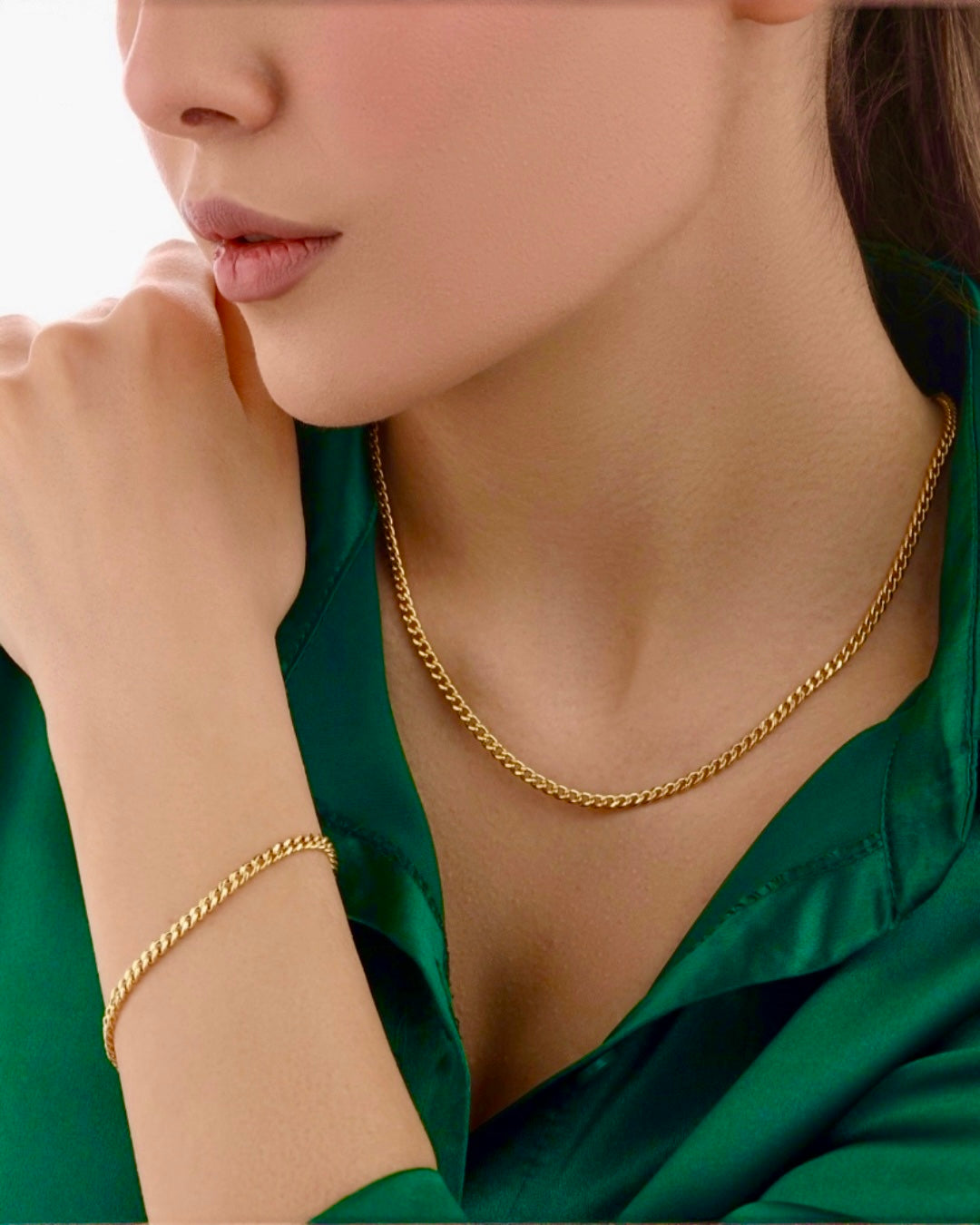 Modell trägt 18 Karat Gold Halskette und passendes Goldarmband in klassischer Panzerkette, hochwertiger handgefertigter Goldschmuck stilvoll kombiniert zum grünen Outfit.