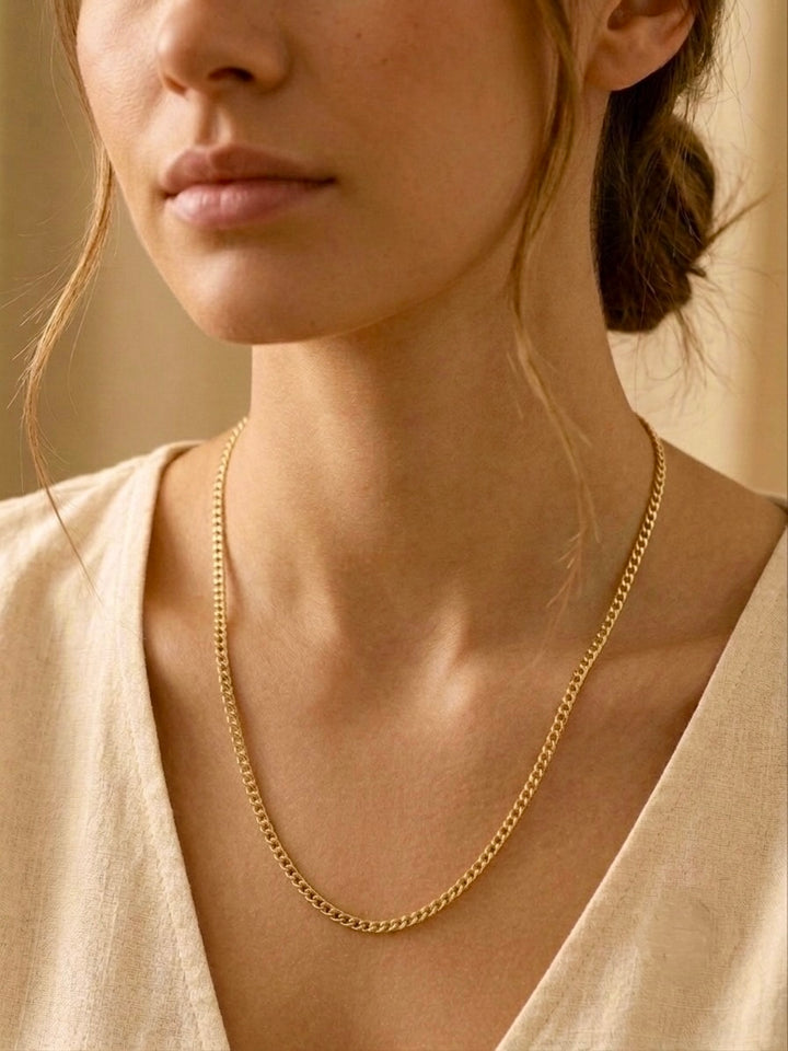 Elegante 18 Karat Panzerkette aus Gelbgold für Damen, getragen als zeitlose Halskette im minimalistischen Stil. Hochwertige Goldkette mit flach anliegenden Kettengliedern – ideal als Alltagsschmuck, für Business-Outfits oder als stilvolles Geschenk.