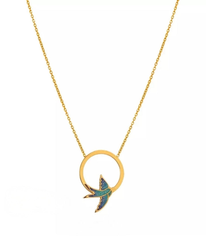 Halskette aus 18k Gelbgold mit kreisförmigem Anhänger und fliegender Schwalbe in Emaille – Symbol für Freiheit und Neubeginn