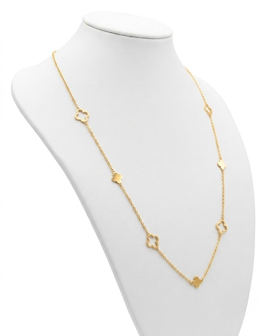 Elegante Halskette aus 18 Karat Gelbgold auf einer weissen Schmuckbüste. Die feine Ankerkette ist mit sieben gleichmässig verteilten Kleeblatt-Elementen verziert, die sich zwischen offenem und massiv poliertem Design abwechseln. Die Kette fällt lang und fliessend und unterstreicht das zeitlose, feminine Design. Der helle Hintergrund und die dezente Präsentation lenken den Fokus auf die hochwertige Verarbeitung und den warmen Glanz des Gelbgolds.