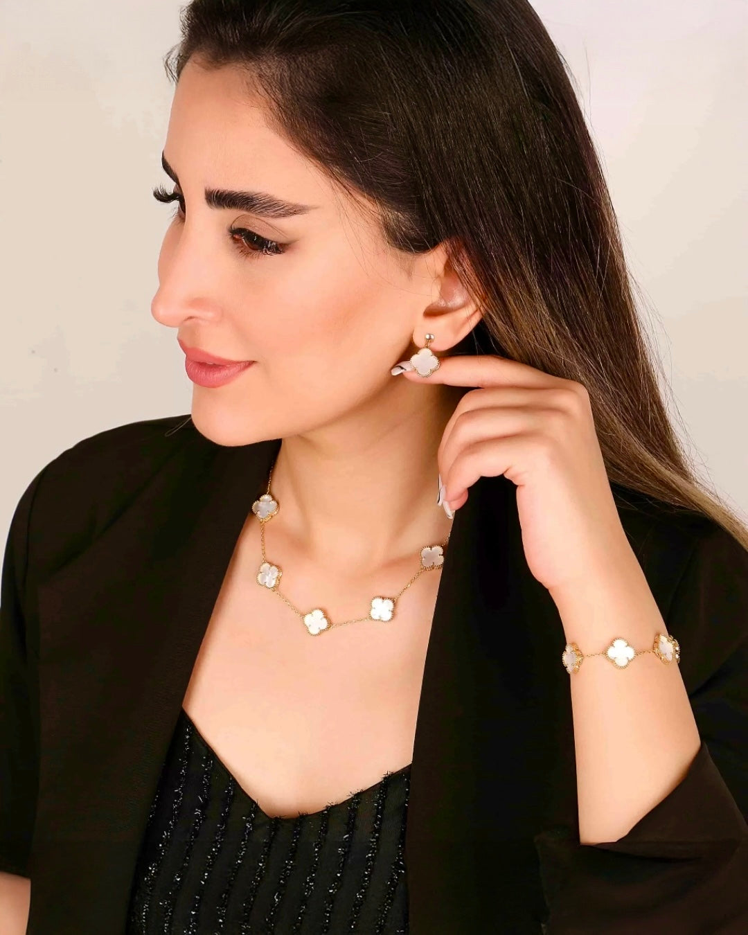Von einem Modell in schwarzem Kleid getragene 18k Perlmutt-Kleeblattkette – elegant &amp; feminin.