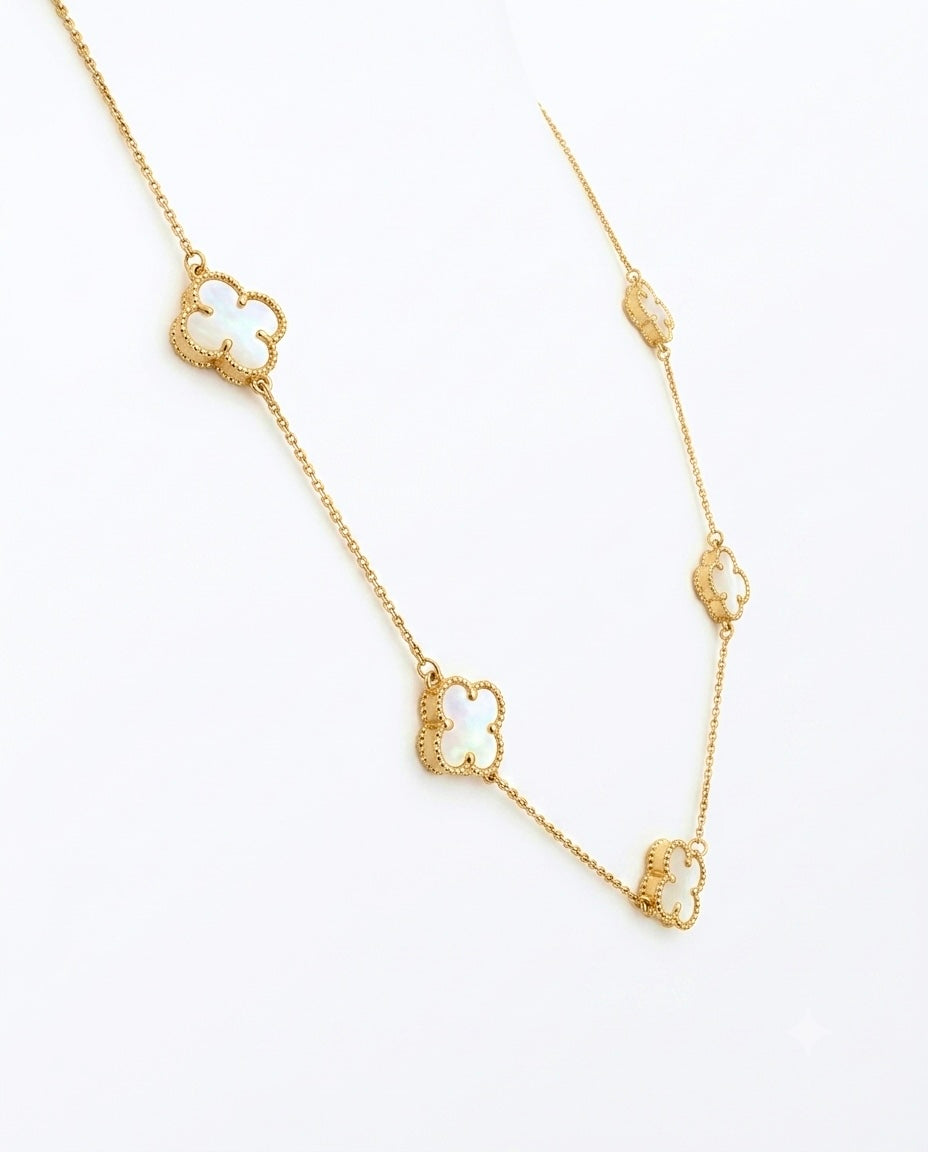 Elegante 18 Karat Gelbgold-Halskette mit vier filigranen Kleeblatt-Anhängern aus schimmerndem Perlmutt. Die zarte Ankerkette verbindet zeitloses Design mit luxuriöser Handwerkskunst und verleiht jedem Outfit einen stilvollen, femininen Akzent. Ideal als hochwertiger Goldschmuck für Alltag und besondere Anlässe.