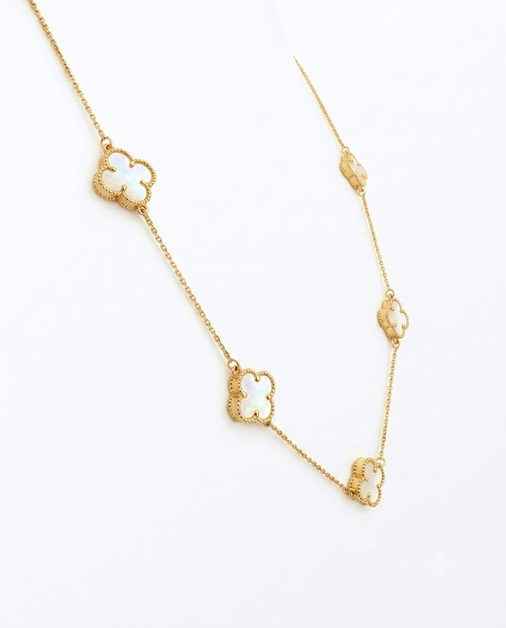 Elegante 18 Karat Gelbgold-Halskette mit vier filigranen Kleeblatt-Anhängern aus schimmerndem Perlmutt. Die zarte Ankerkette verbindet zeitloses Design mit luxuriöser Handwerkskunst und verleiht jedem Outfit einen stilvollen, femininen Akzent. Ideal als hochwertiger Goldschmuck für Alltag und besondere Anlässe.