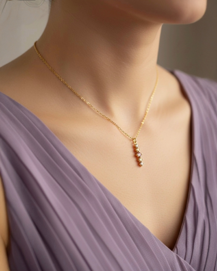 Elegante 18k Gelbgold-Halskette mit feinem Diamant-Anhänger, getragen am Hals einer Frau, filigraner Goldschmuck mit vertikal angeordneten Diamanten, zeitloser Luxus, hochwertige Goldkette