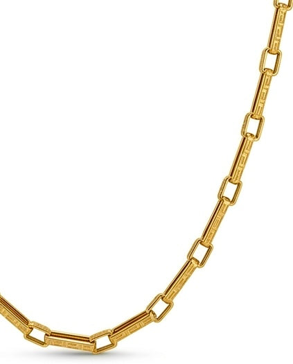 Nahaufnahme einer Halskette aus 18 Karat Gelbgold mit länglichen, rechteckigen Gliedern im modernen Paperclip-Design. Die schmalen Glieder sind mit einem filigranen griechischen Mäander-Muster graviert und wechseln sich mit polierten, offenen Rechteckgliedern ab. Die Detailaufnahme hebt die hochwertige Verarbeitung und den warmen Goldglanz vor einem weissen Hintergrund hervor.