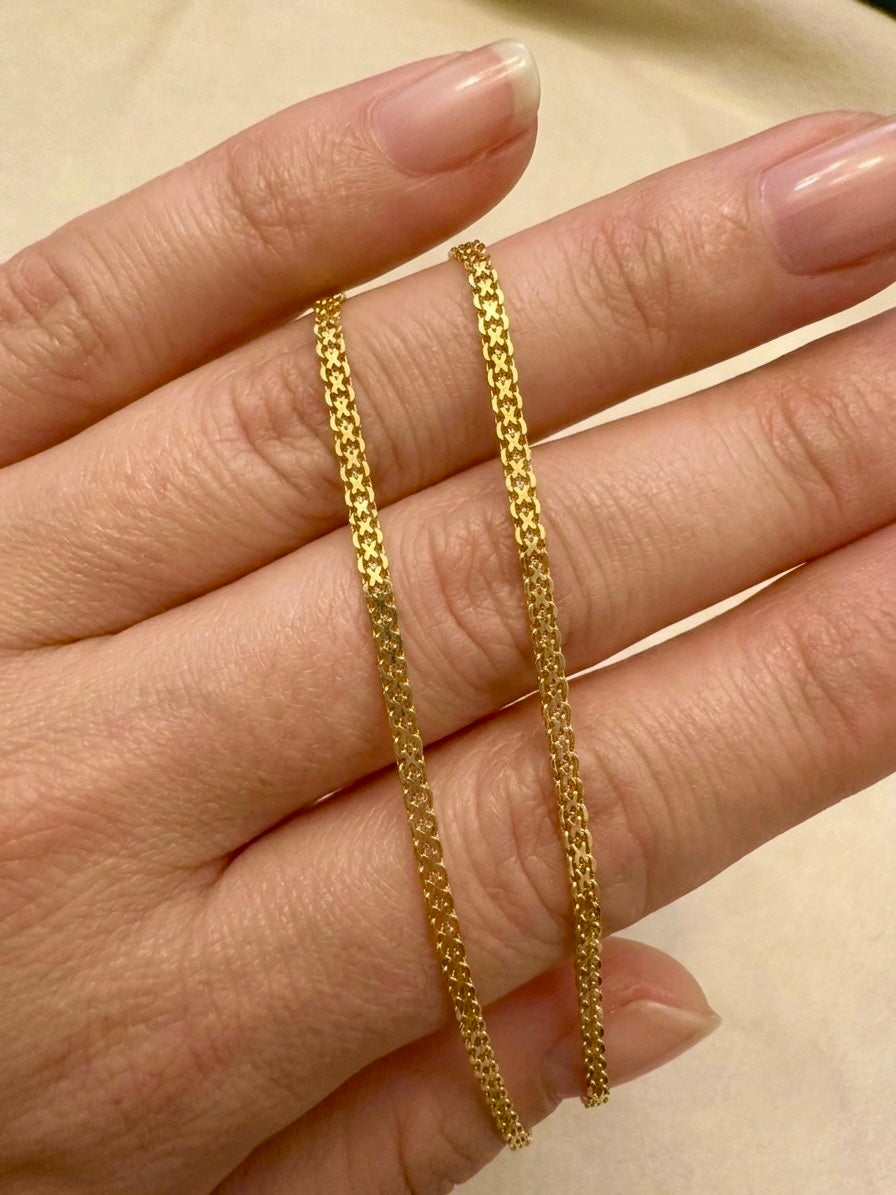 Elegante 18 Karat Gelbgold-Halskette mit filigranem Muster, auf einer Hand drapiert. Die hochwertige Goldkette überzeugt durch ihre feine Verarbeitung, ihren warmen Goldglanz und ihr zeitloses Design – ideal als edler Alltagsschmuck oder stilvolles Geschenk.