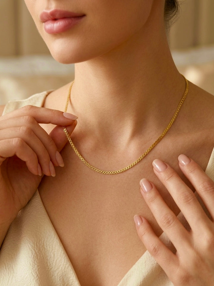 Damenhals mit feiner Halskette aus 18 Karat Gelbgold in elegantem Design, stilvoll getragen und detailreich präsentiert.
