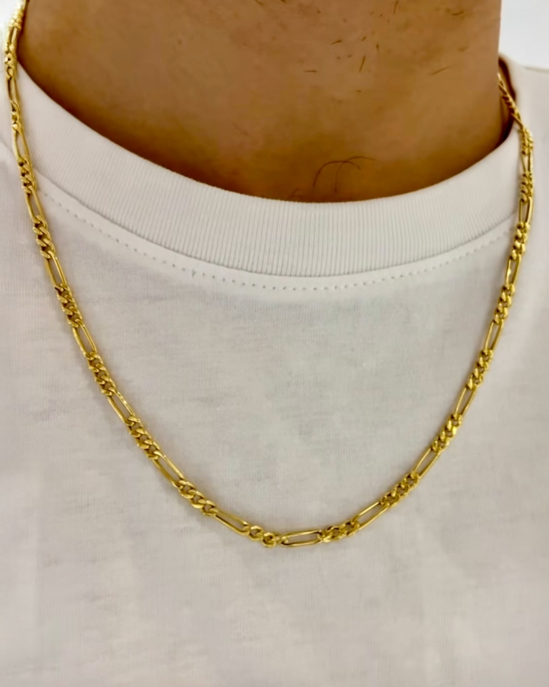 Hochwertige 18k-Gelbgold-Figaro-Halskette mit gedrehten Gliedern, getragen als stilvolles Herren-Accessoire über einem weißen T-Shirt