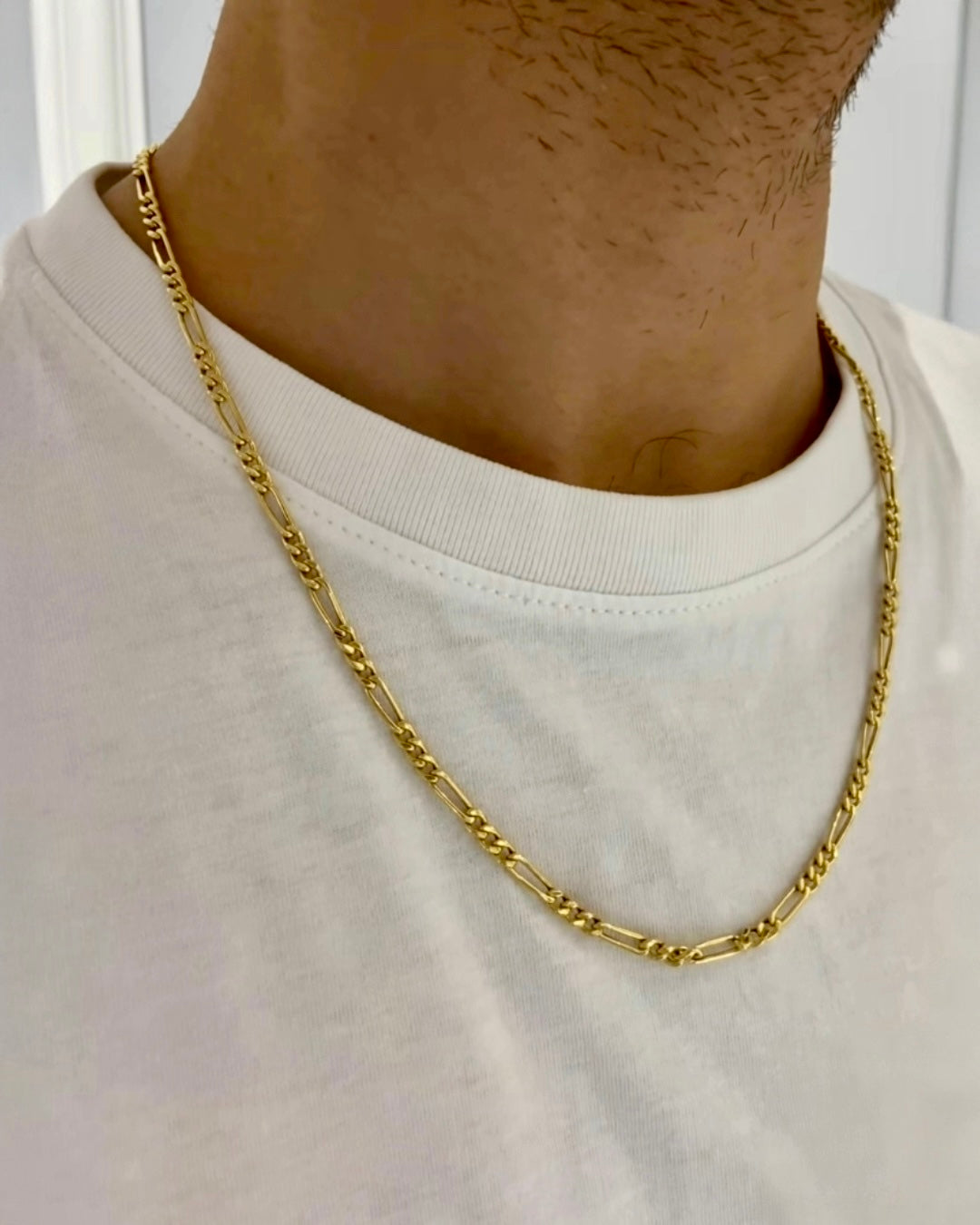 18k Gelbgold-Figaro-Halskette mit strukturierten Gliedern, getragen als stilvolles Accessoire über einem weißen T-Shirt.