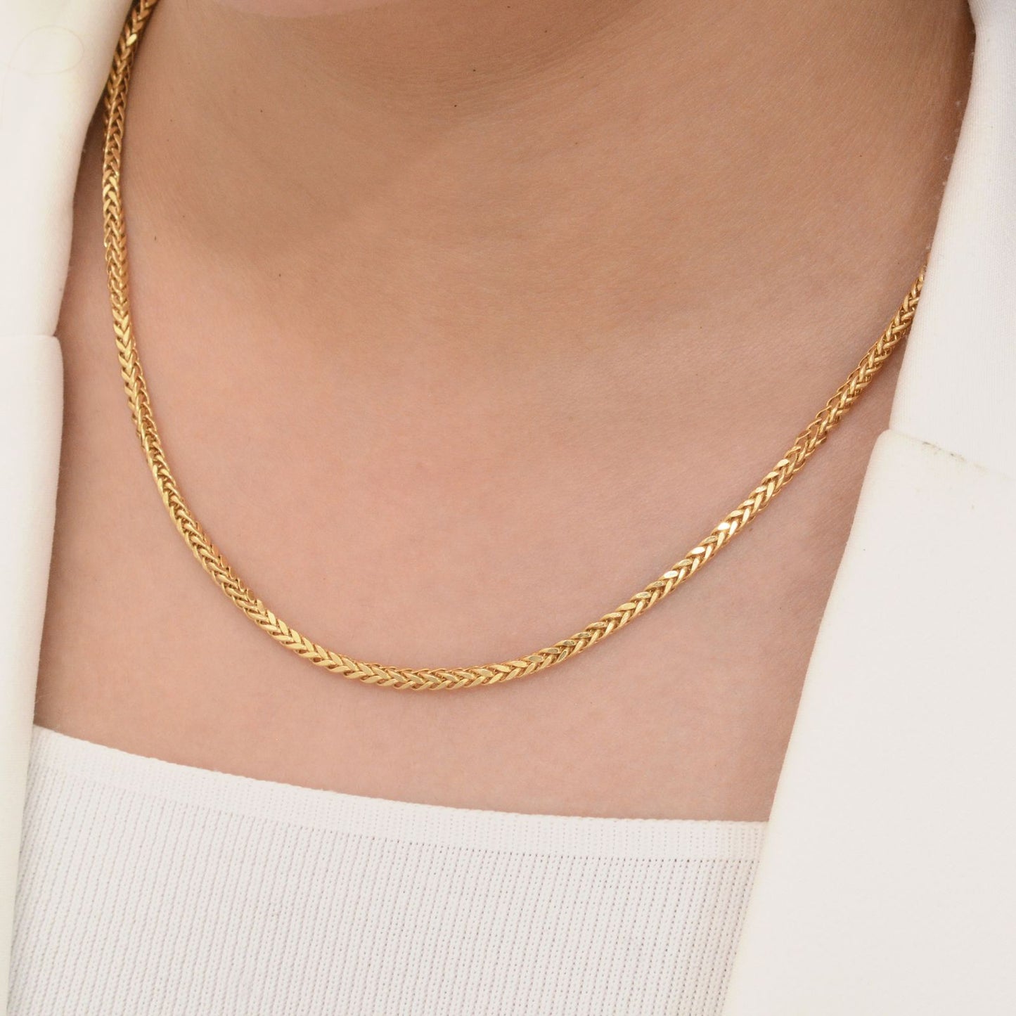 Zopfmuster-Halskette aus 18k Gelbgold mit 3 mm breiten Gliedern – elegant getragen im weiblichen Dekolleté