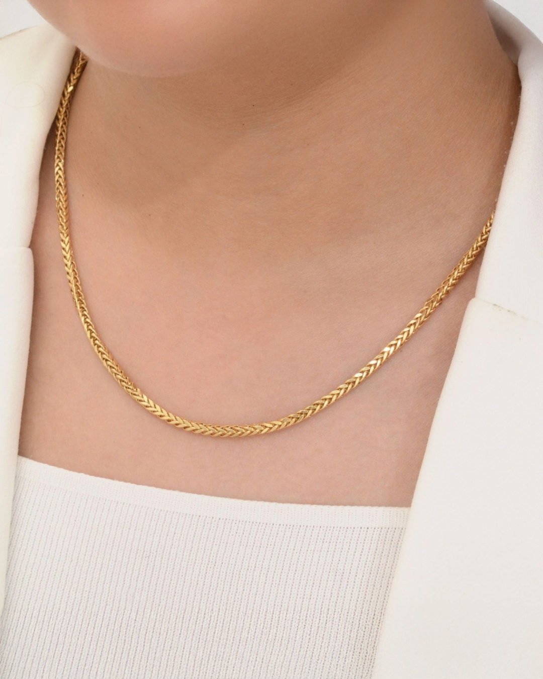 Zopfmuster-Halskette aus 18k Gelbgold mit 3 mm breiten Gliedern – elegant getragen im weiblichen Dekolleté