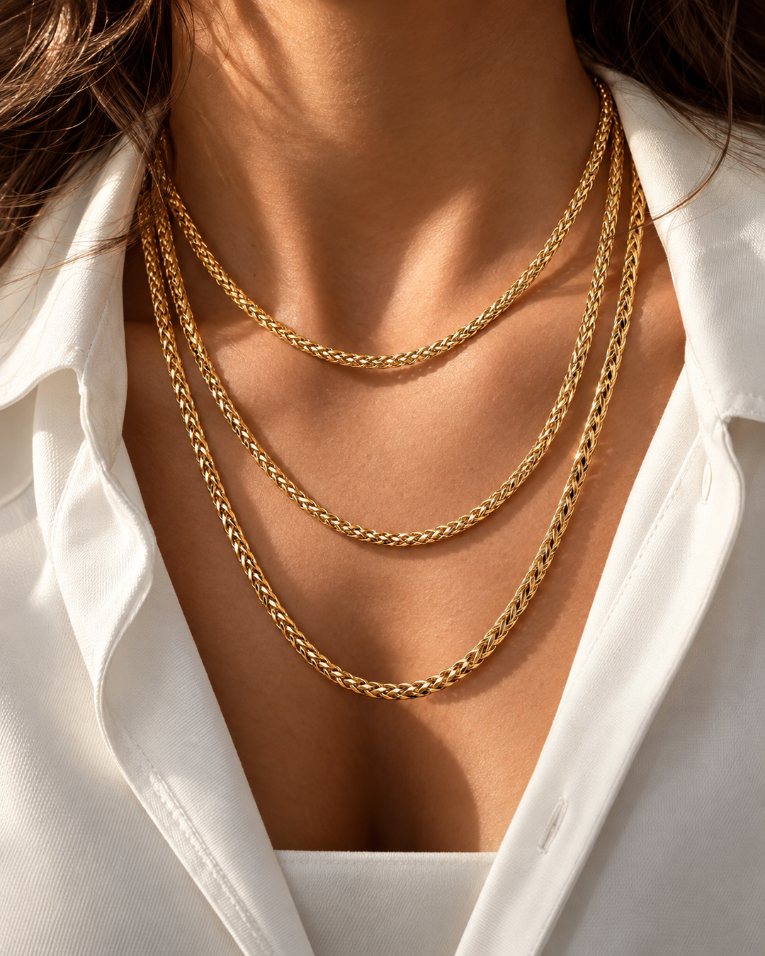 Halskette aus 18k Gelbgold – Zanjir-e Miro-ye Bosorg (Grosse Mirokette). Mehrlagige, massive Miro-Ketten in glänzendem Gold, getragen über einem weißen Hemd.