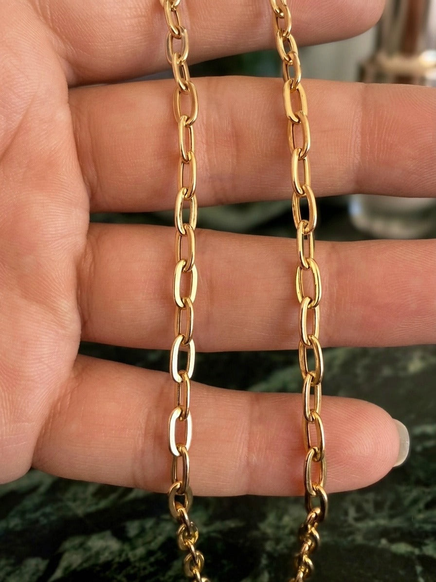 18 Karat Gelbgold Halskette im Ankerstil mit länglichen, polierten Gliedern. Zeitloses, elegantes Design in hochwertiger Handarbeit, fotografiert auf einer Hand zur Darstellung der feinen Gliederstruktur und des warmen Goldglanzes.