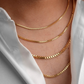 Mehrlagig getragene 18k Gelbgold-Halsketten mit eckiger Gliederstruktur (Box Chain) an einem männlichen Hals, kombiniert mit offenem weissen Hemd – minimalistischer, eleganter Goldschmuck mit modernem Layering-Look.