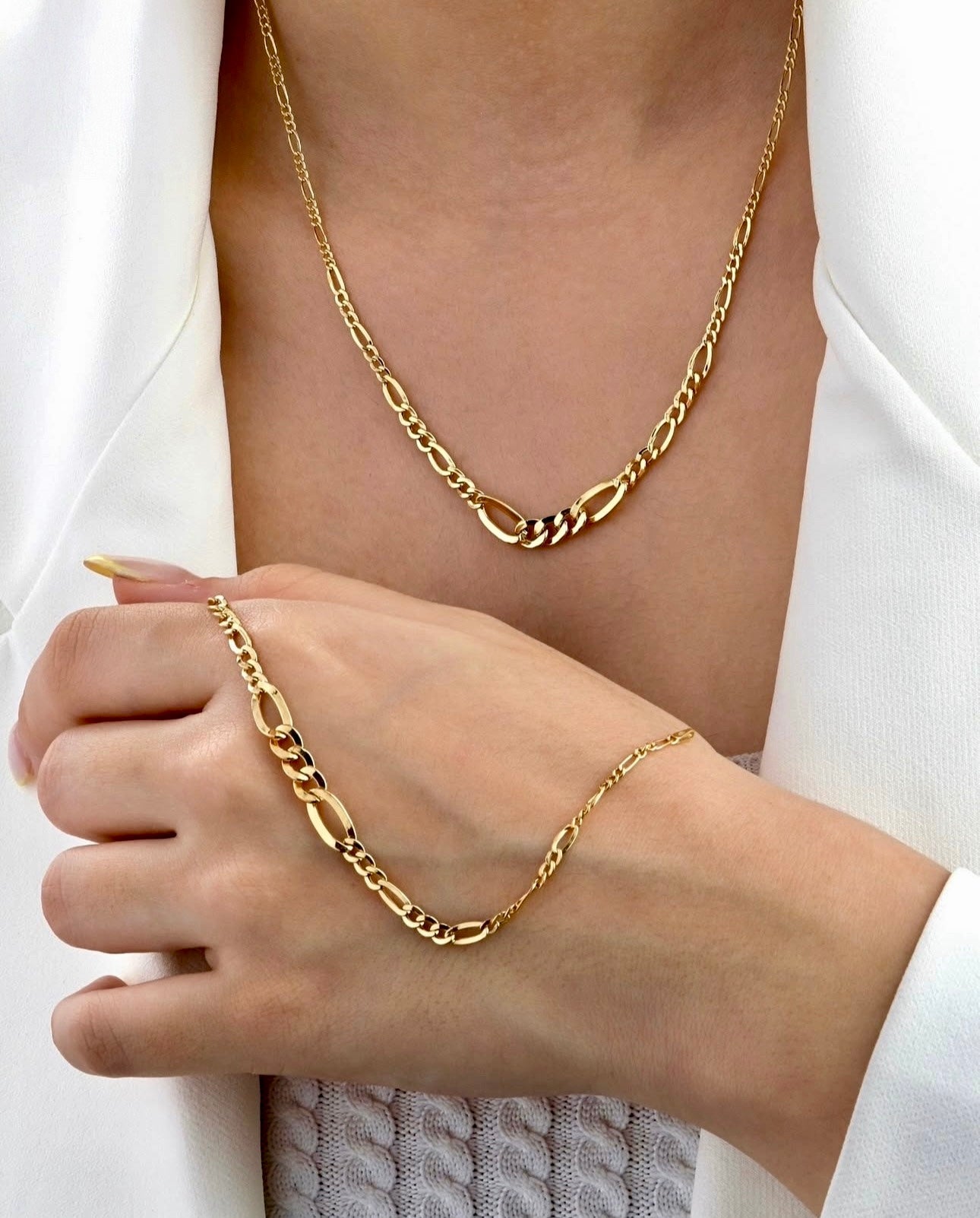 Halskette aus 18k Gelbgold – Zanjir-e Figaro Conic – mit markanten, abwechselnd großen und kleinen Gliedern, getragen mit passendem Armband an der Hand.