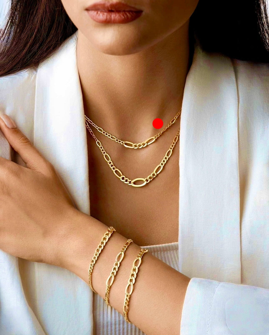 Elegante Figaro-Kette aus 18 Karat Gelbgold mit abwechselnden ovalen und kürzeren Kettengliedern, modern kombiniert mit passendem Armband-Set, getragen zu weißem Outfit.