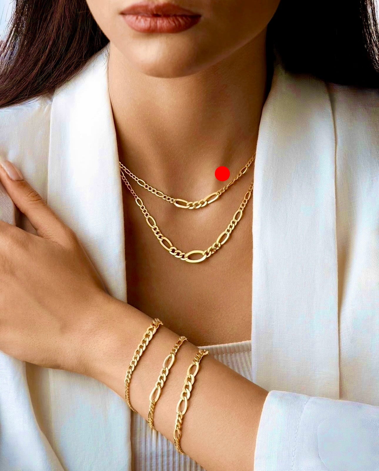 Elegante Figaro-Kette aus 18 Karat Gelbgold mit abwechselnden ovalen und kürzeren Kettengliedern, modern kombiniert mit passendem Armband-Set, getragen zu weißem Outfit.