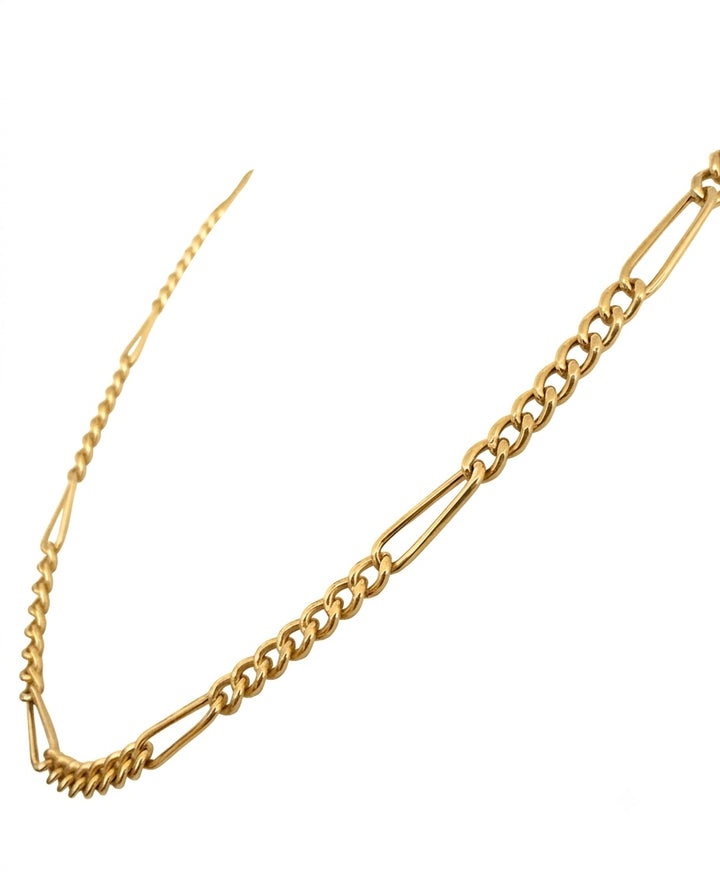 Nahaufnahme einer eleganten Figaro-Halskette aus poliertem 18-karätigem Gelbgold. Das asymmetrische Kettendesign kombiniert längliche, ovale Glieder mit mehreren kleineren Rundgliedern und verleiht der Kette eine zeitlose, moderne Optik. Die Kette ist freigestellt auf weissem Hintergrund fotografiert und hebt den warmen Goldglanz sowie die feine Verarbeitung der einzelnen Glieder hervor.