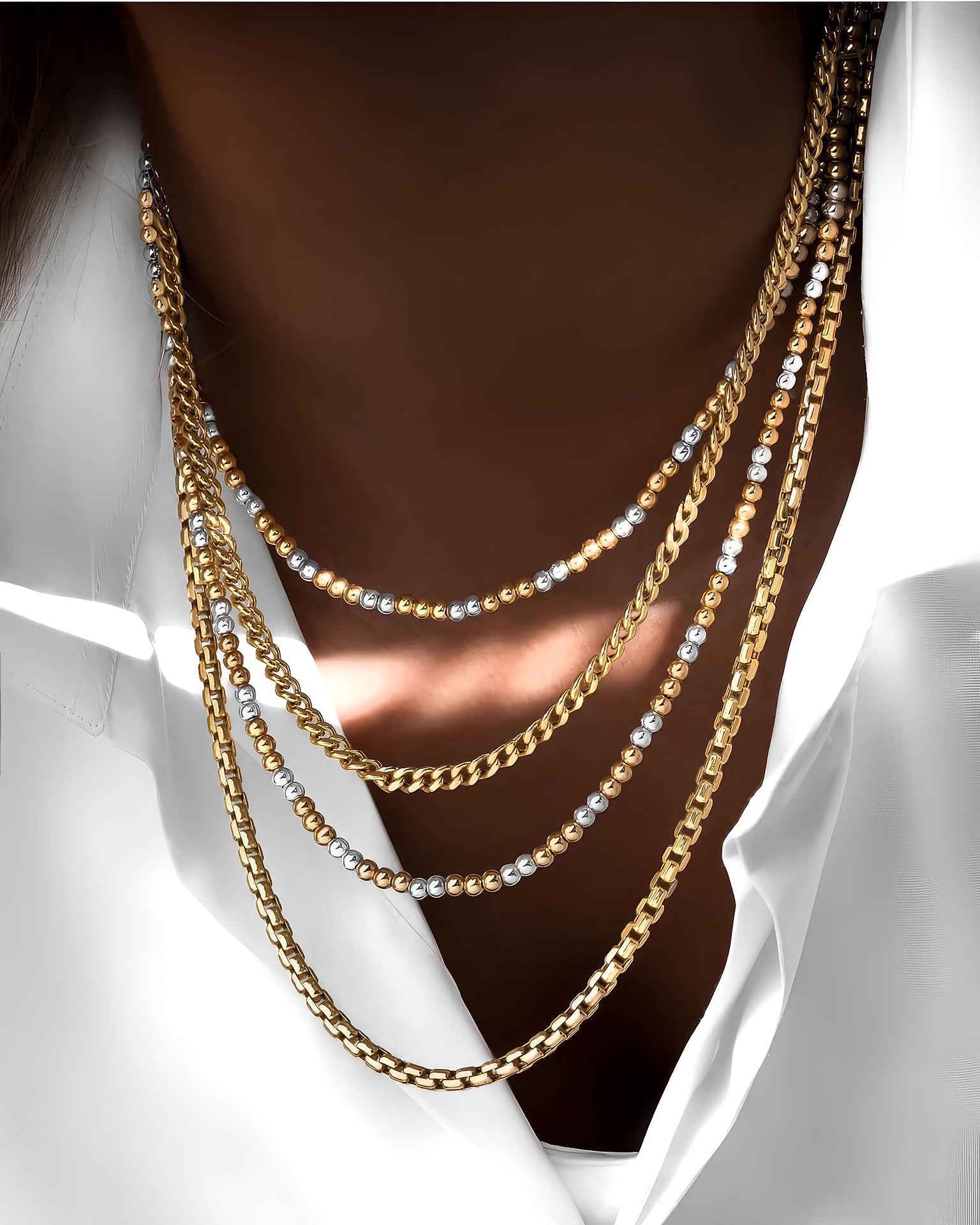 Zweifarbige Goldperlenkette kombiniert mit weiteren Ketten – 18k Gelb- und Weissgold, getragen zur weißen Bluse im Lagenlook