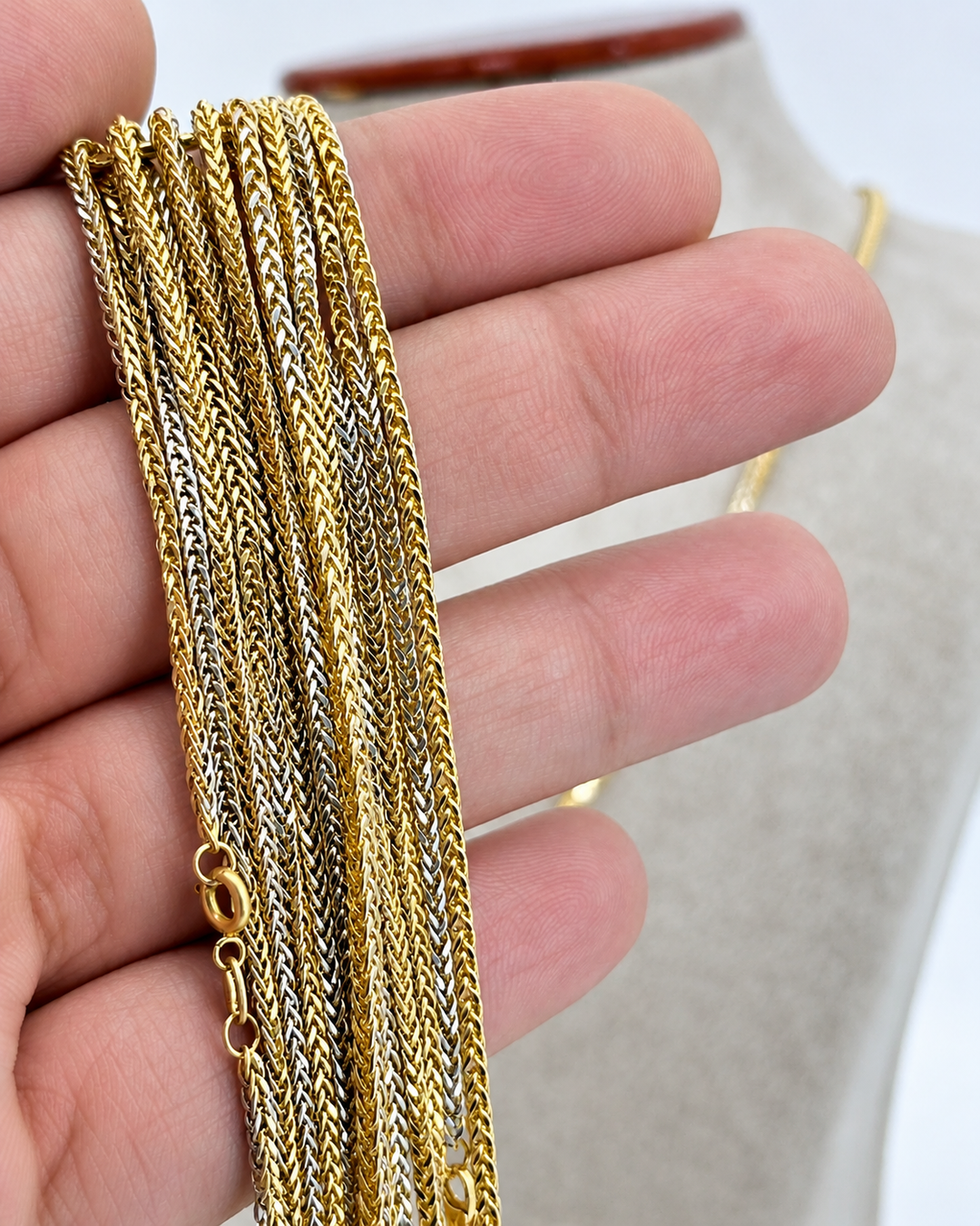 Handgefertigte Halskette aus 18k Gelb- und Weißgold – feine zweifarbige Miro-Kette mit elegantem Flechtmuster, gehalten in der Hand zur Darstellung der filigranen Struktur.