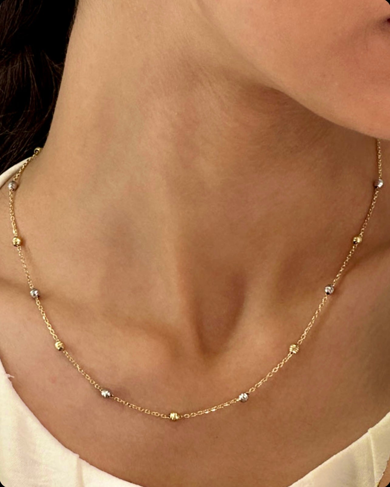 Feine Halskette aus 18k Gelbgold & Weissgold – Morvaridha-ye Talâ (Perlen aus Gold). Zarte Kette mit kleinen Gold- und Weissgoldkugeln, elegant am Hals getragen.