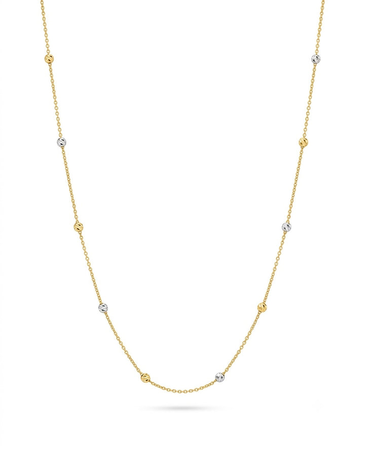 Feine Halskette aus 18-karätigem Gelbgold mit zarten, gleichmässig verteilten Kugel-Elementen in Gelb- und Weissgold. Die diamantierten Kugeln reflektieren das Licht dezent und verleihen der filigranen Kette einen eleganten, luftigen Look. Freigestellt vor weissem Hintergrund.