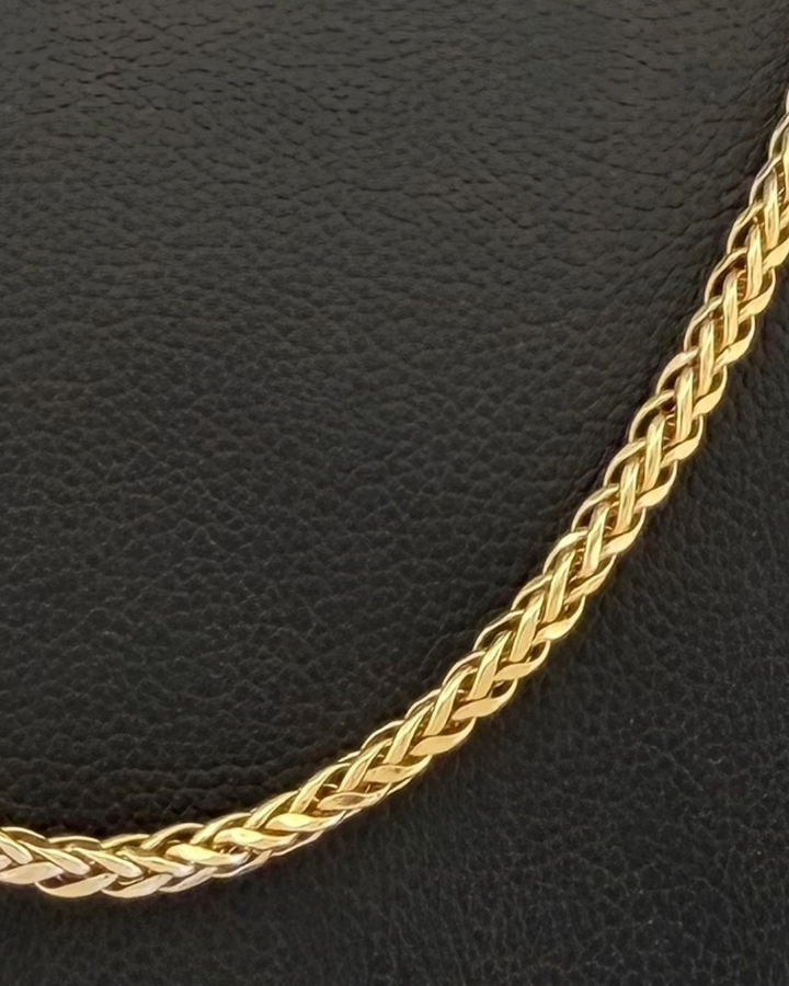Makroaufnahme der geflochtenen Struktur einer Gelbgold- und Weissgold-Mirokette