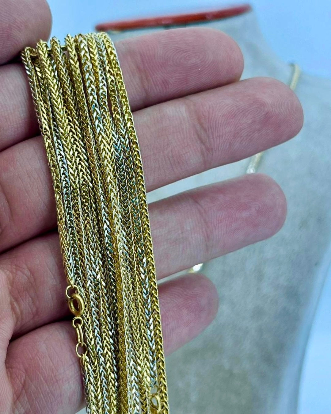 Handgefertigte Halskette aus 18k Gelb- und Weißgold – feine zweifarbige Miro-Kette mit elegantem Flechtmuster, gehalten in der Hand zur Darstellung der filigranen Struktur.
