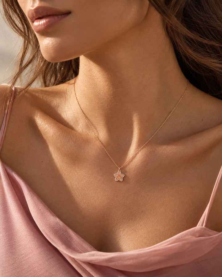 Filigrane Halskette in Roségold mit kleinem sternförmigem Anhänger an einem Model im rosafarbenen Kleid – eleganter 18 Karat Goldschmuck von Ziba Gold.