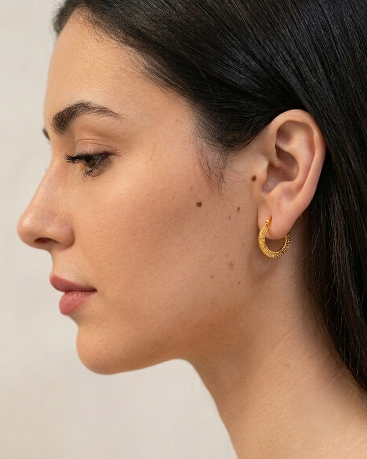 Elegante 18 Karat Gelbgold-Creole mit strukturierter Oberfläche am Ohr getragen. Zeitloser 750er Goldohrring für Damen in hochwertiger Verarbeitung – stilvolle Seitenansicht mit natürlichem Tragebild.