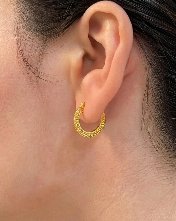 18 Karat Gelbgold-Creole mit strukturierter Oberfläche am Ohr getragen. Eleganter, zeitloser Goldohrring für Damen in hochwertigem 750er Gold – Nahaufnahme mit natürlichem Tragebild.