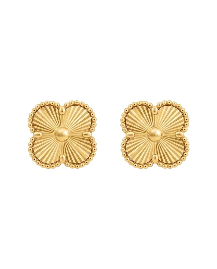 18 Karat Gold-Ohrstecker in Form eines vierblättrigen Kleeblatts mit fein gravierter Sonnenstrahlstruktur und filigranem Perlenrand. Die eleganten Stecker vereinen zeitlose Eleganz mit persisch inspirierter Handwerkskunst und eignen sich für Alltag sowie besondere Anlässe. Freigestellt auf weissem Hintergrund.